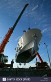 ship-being-lifted-by-crane-on-a-shipyard-drydock-C43W0E.jpg